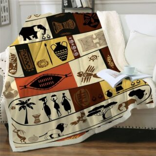 Plaid marron et beige avec fresques africaines décoratives étendu sur un canapé blanc avec un livre et une tasse posée dessus