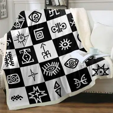 Plaid imprimé symboles tribaux noir et blanc sur un canapé