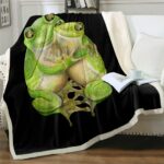 Plaid noir avec motif grenouilles amoureux sur un canapé