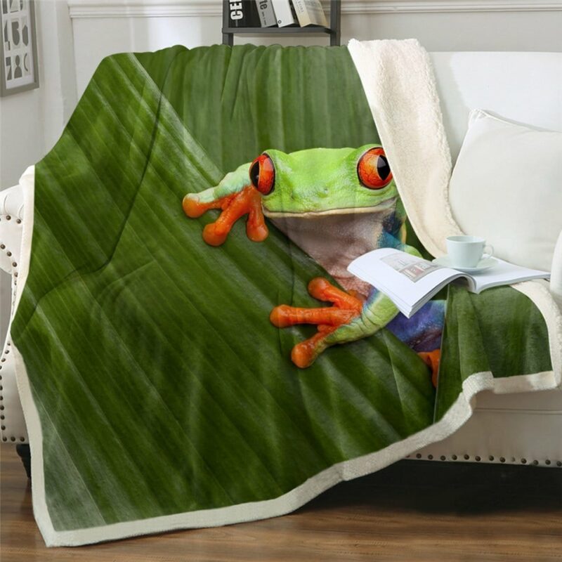 Plaid polaire vert à motif grenouille sur un canapé