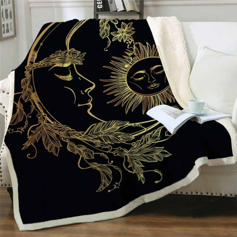 Plaid noir avec lune et soleil dorés sur un canapé blanc