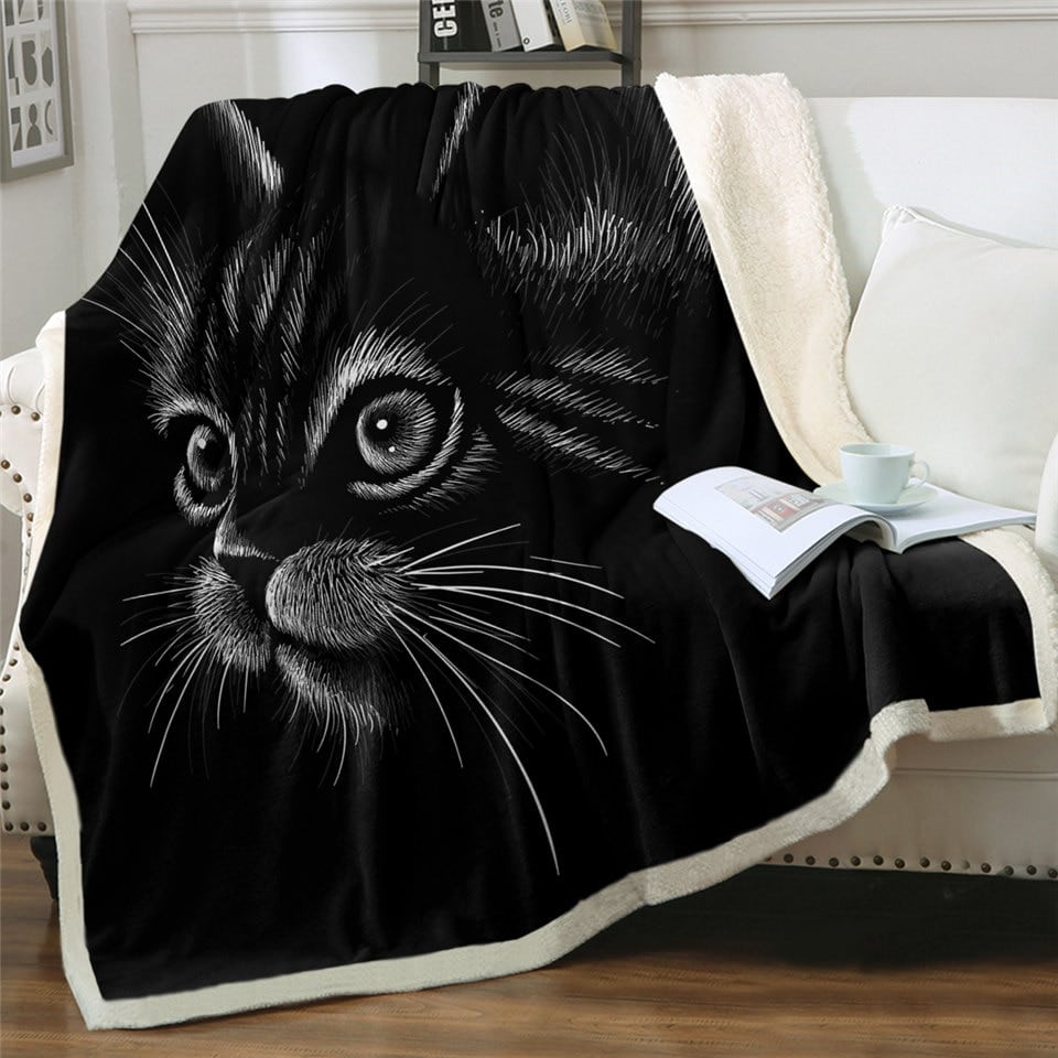 Couverture polaire petit chat noir beaucoup trop mignon sur un canapé