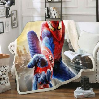 Plaid polaire coloré à l'effigie de Spiderman en plein action la main tendue. Ce plaid est étendu sur un canapé blanc dans un décor de salon avec un livre et une tasse posée dessus.