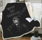 Plaid noir avec image de la tête de Joker avec inscription "why so serious? "sur un canapé blanc.
