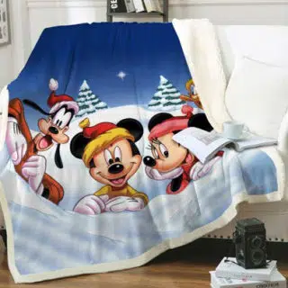 Plaid polaire Disney Mickey, Minnie et Pluto sur un canapé blanc