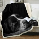 Plaid polaire noir avec motif tête de chien sur un canapé