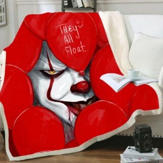 Plaid rouge avec motif Thriller avec visage du clown CA entouré de ballons rouges 3D sur un canapé blanc . Il y a un livre ouvert sur le dessus avec une tasse blanche posée par- dessus.