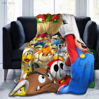 Un plaid polaire très coloré avec multiples personnages de Mario Bros. Il est étendu sur un canapé deux places gris foncé.