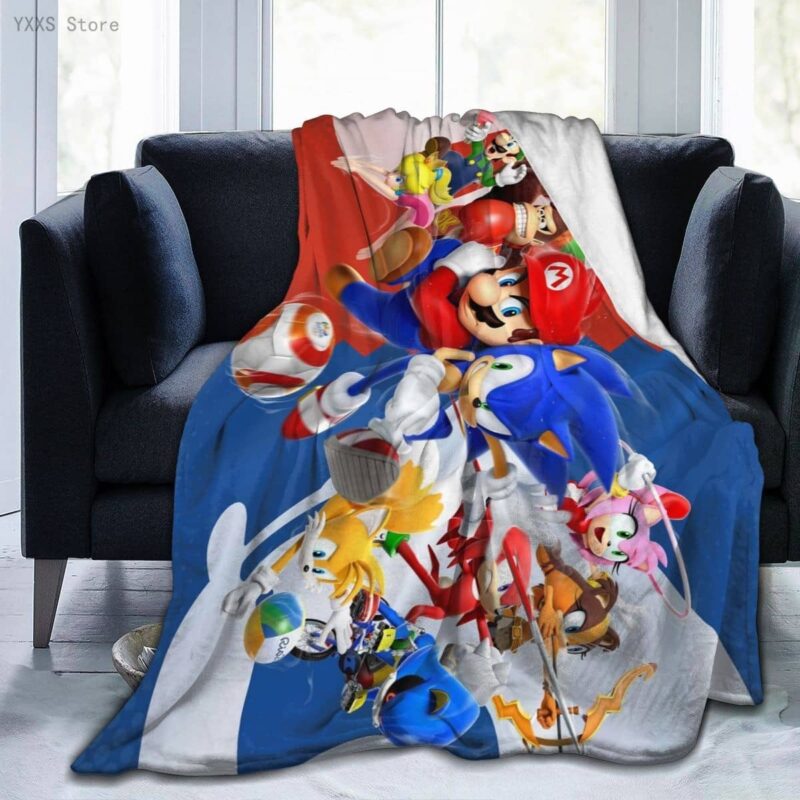 Plaid polaire coloré en bleu et rouge avec les personnages emblématiques de Sonic et Mario Bros. Il est étendu sur un canapé gris deux places .