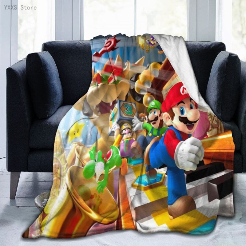 Plaid coloré représentant les personnages de Mario, Luigi et Bowser en action. Il est étendu sur un canapé gris foncé à deux places entre deux coussins.