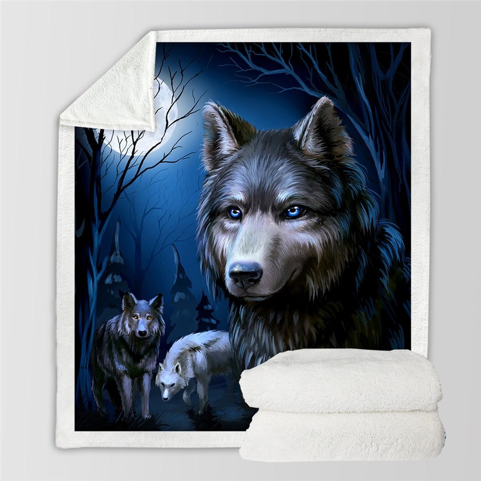 Dans le coin d'un salon, sur un canapé blanc, on voit un plaid orné d'un loup qui hurle à la lune. Il est entouré d'arbres.