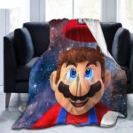 Plaid polaire avec la tête de Mario Bros en gros plan dans les étoiles. Il est étendu sur un canapé deux places gris foncé.