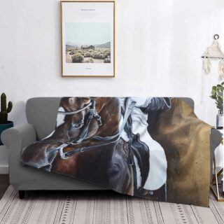 Dans un salon à la décoration minimaliste, on voit sur un canapé gris, une couverture ornée d'une photo de cheval.
