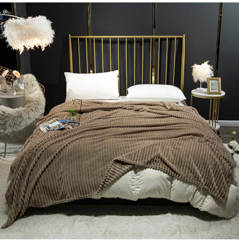 Couverture marron en flanelle côtelée servant de couvre-lit sur un grand lit 2 places à barreaux dorés dans un décor de chambre cosy au mur noir.