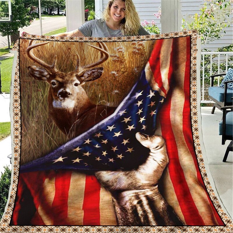 On voit une femme blonde d'une quarantaine d'année qui se trouve sous le porche d'une maison qu'on imagine facilement américaine qui tient une couverture à l'effigie d'un cerf et du drapeau américain.