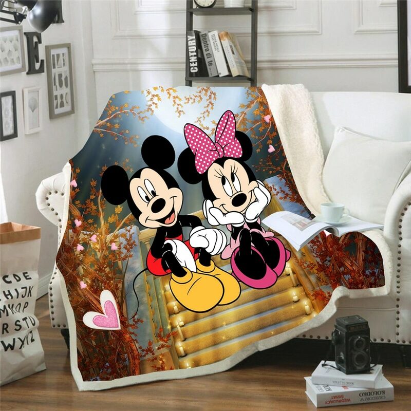 sur un canapé blanc dans un salon , un plaid est installé et représente mickey et minnie assis sur des marches d'escalier en amoureux
