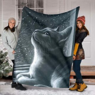 deux jeunes femmes tiennent ouvert pour que l'on voit le motif, un plaid avec un chat gris en train de regarder la neige tomber