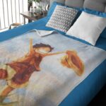 Un plaid one piece étalé sur un lit à la couverture bleue et la tête de lit grise.