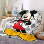 Plaid Mickey en couleur sur fond gris représentant Minnie, posé sur un canapé beige