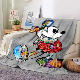 Plaid Mickey en cartoon coloré sur fond gris, posé sur un canapé beige
