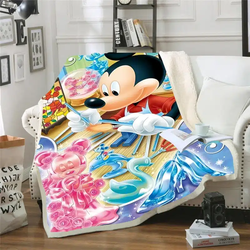Plaid Mickey coloré dessinant Minnie avec du rose et du bleu, posé sur un canapé blanc