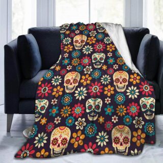 Plaid tête de mort mexicaines et fleurs sur fond noir présenté sur un canapé noir