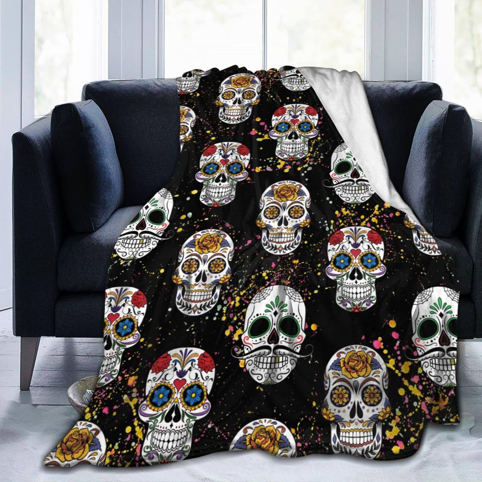 Plaid tête de mort mexicaines colorées présenté sur un canapé noir