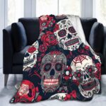 Plaid tête de mort mexicaines rouges et noires présenté sur un canapé noir