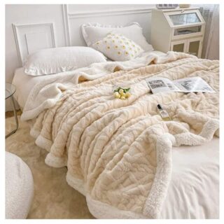 Plaid polaire et coton beige disposé sur un lit, dans une chambre à coucher.