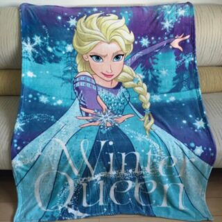 Couverture bleue Reine des Neiges avec le personnage Elsa, posée sur un canapé